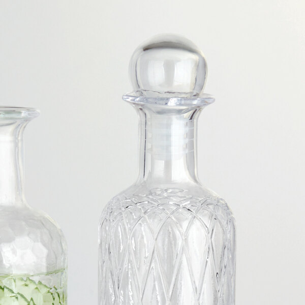 Two clear glass bottles with American Metalcraft glass stoppers.