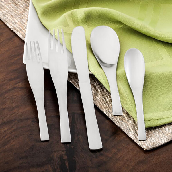 A Walco stainless steel dinner knife on a white plate with a green napkin.