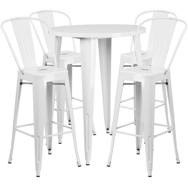 A white metal bar height table with four white chairs.