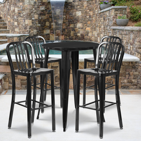 A Flash Furniture black metal bar table with four black chairs.