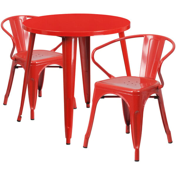 A red metal table with two red metal arm chairs.