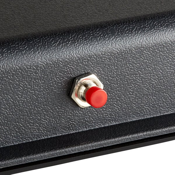 A black metal box with a red button.