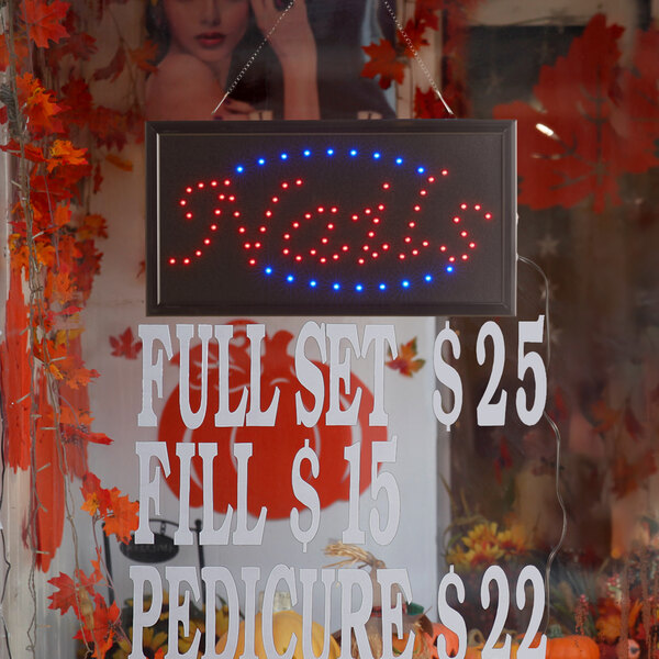 A rectangular LED sign that says "Nails" with lights on it.