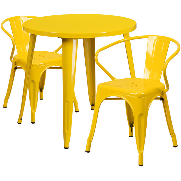 A yellow metal table with two yellow metal chairs.