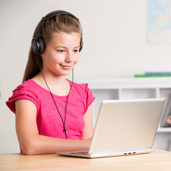 A woman using a Kensington Hi-Fi Headphones while using a laptop.