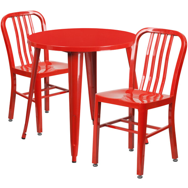 A red metal table with 2 red chairs.