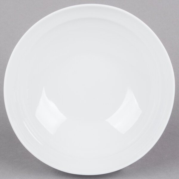 An Arcoroc white bowl with a curved edge.