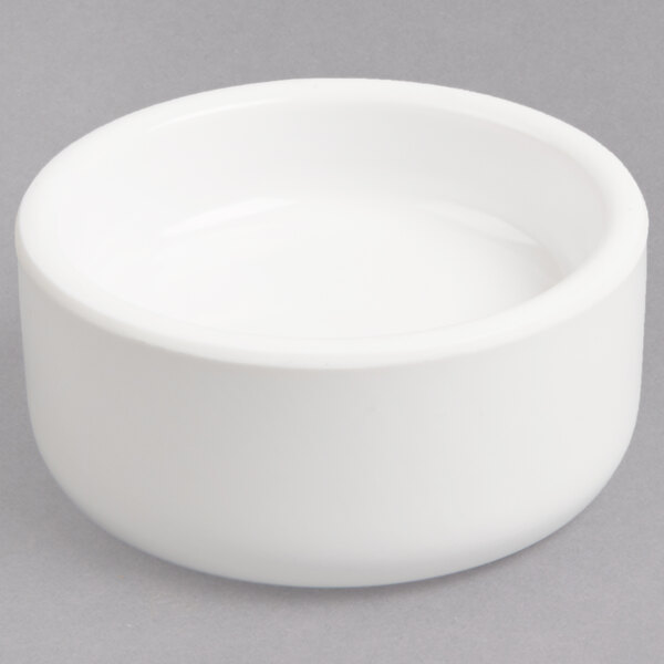A white bowl with a lid on a gray surface.