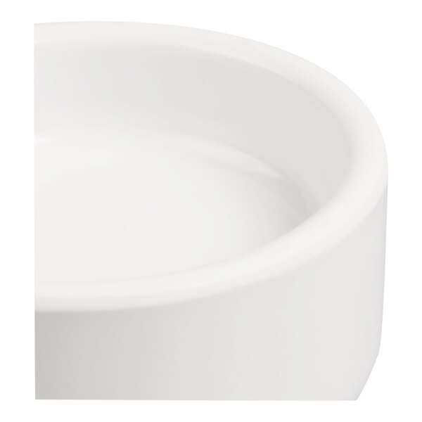 A close-up view of a white, round dish with smooth sides and a slightly raised rim.