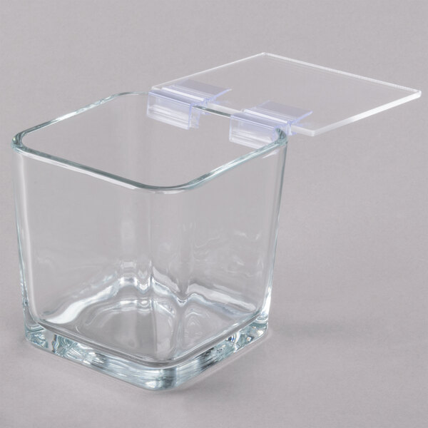 A clear square glass container with a hinged plastic lid.
