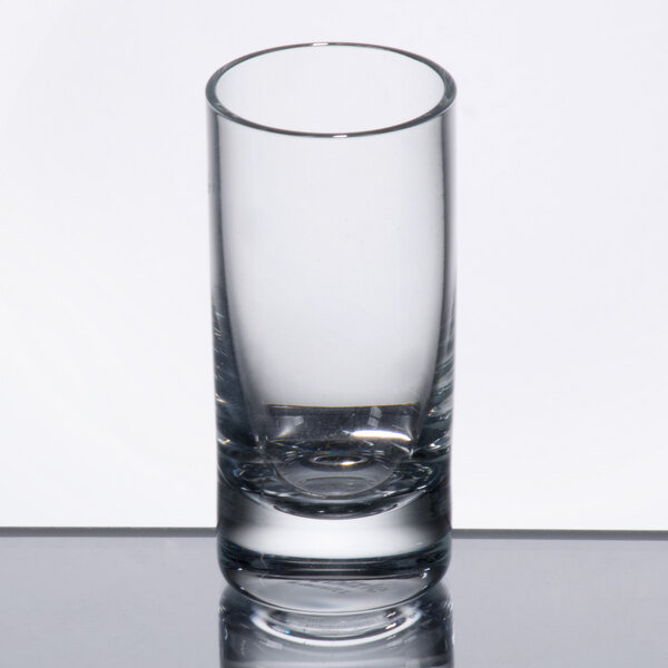 A Stolzle New York shot glass on a reflective surface.