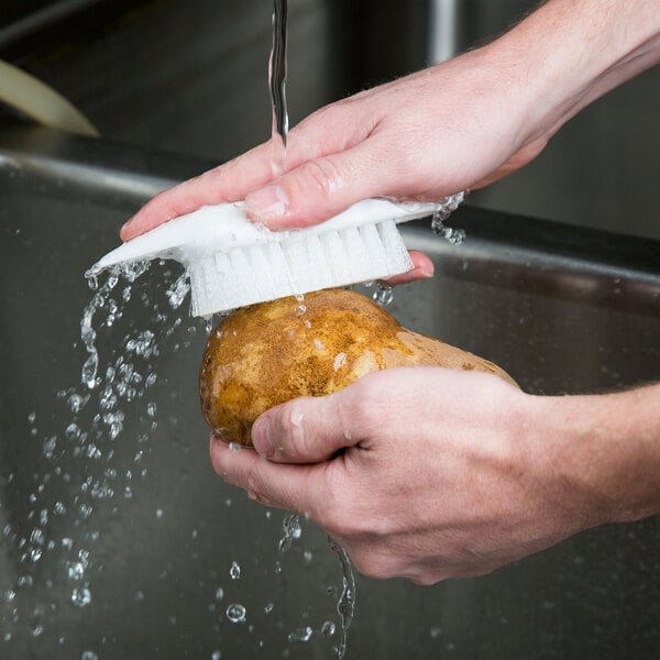 a person washing a potato