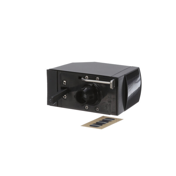 A black box with a metal handle and a small piece of paper inside.