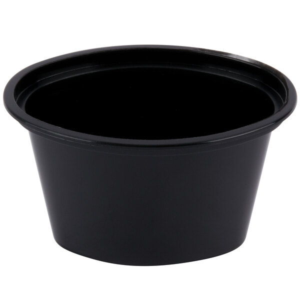 A black Newspring oval souffle container with a clear lid.