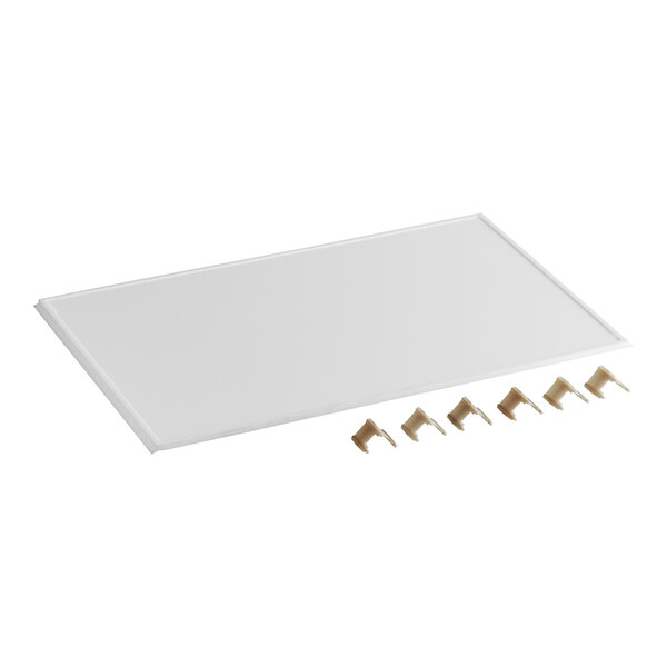 A white rectangular ceramic tray with four metal pins on it.