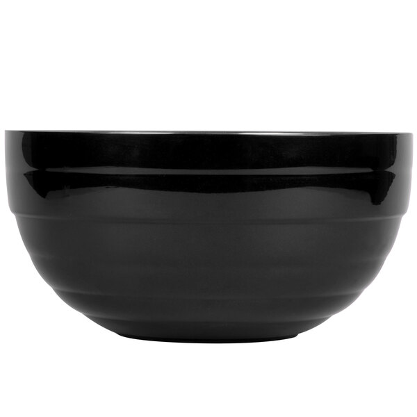 A close-up of a black Vollrath double wall metal bowl with a beehive design.