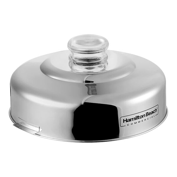 A silver metal lid for a Hamilton Beach blender.