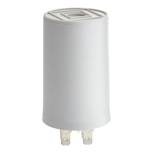 A cylindrical white component with two metal prongs at the bottom, likely an electrical capacitor.