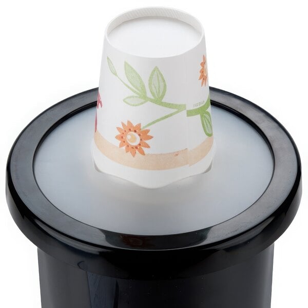 A paper cup on top of a black San Jamar EZ-Fit cup dispenser.