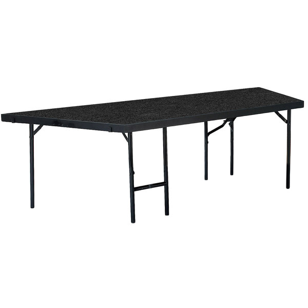 A National Public Seating rectangular portable stage pie unit with black carpet on top.