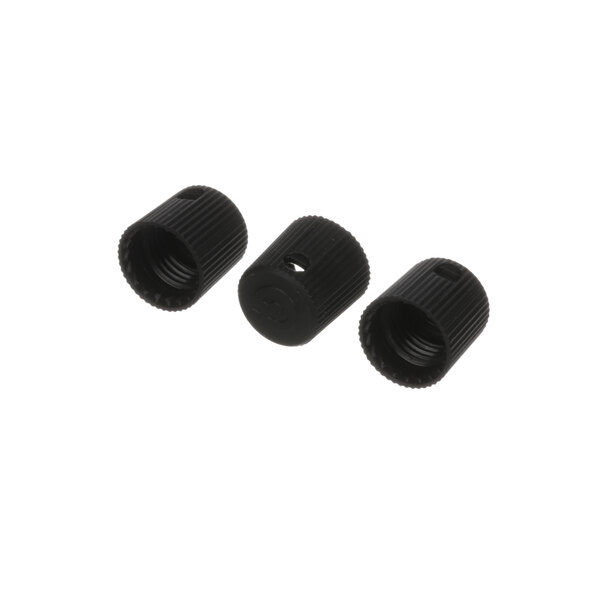 A close-up of three black plastic caps.