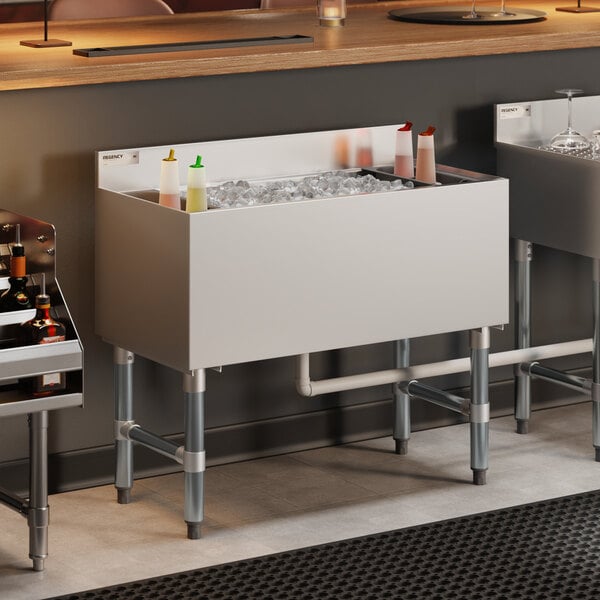 An 18-inch by 36-inch stainless steel underbar ice bin with bottle holders designed for commercial use.