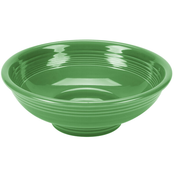 A green bowl with a white stripe on a circular pedestal.