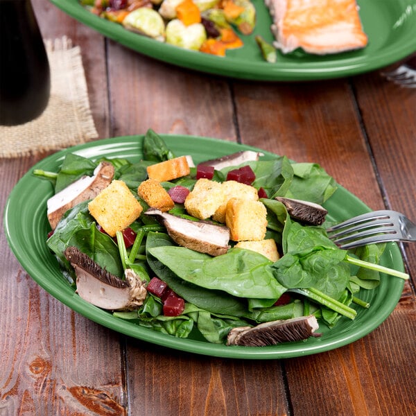 A Fiesta china platter with a salad and a fork on a table.