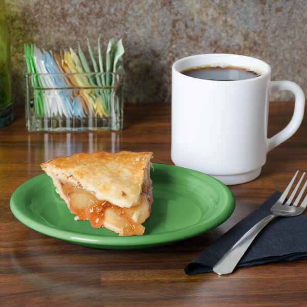 A Fiesta® Meadow china appetizer plate with a slice of apple pie on it next to a white mug of coffee.