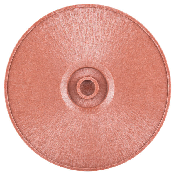 A close-up of a paprika-colored circular polyethylene tortilla server with a hole in the middle.