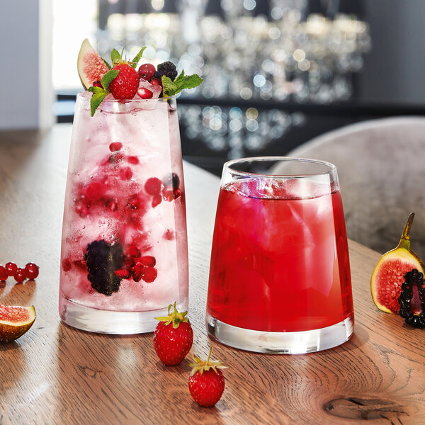 Two Chef & Sommelier Aska tumblers filled with red fruit juice and ice on a table.