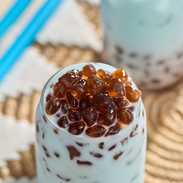 A glass of milk with brown bubbles.