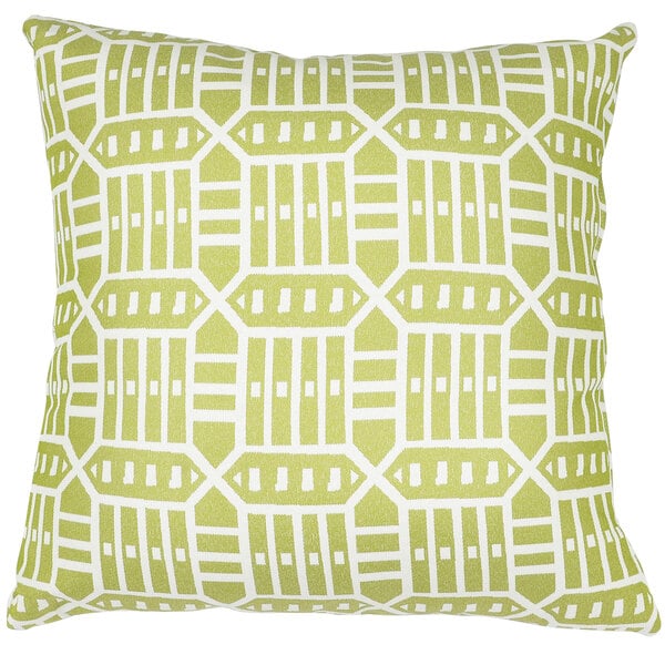 An Astella Roland Green throw pillow with a white geometric pattern on an outdoor patio chair.