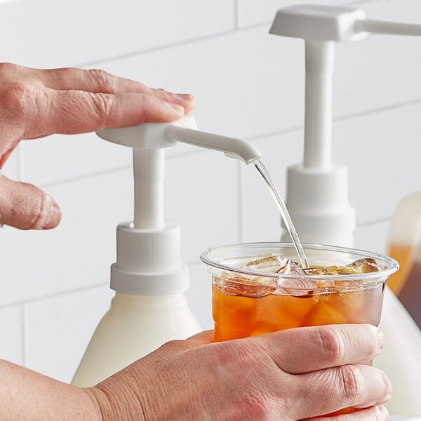 A person pouring Narvon Simple Syrup into a cup.