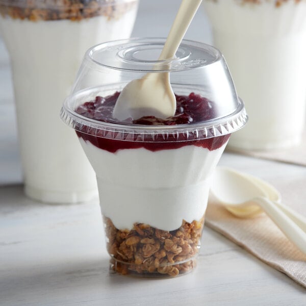 A 9 oz. PET plastic dessert cup with a spoon in it.