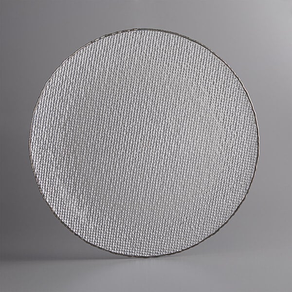 A clear glass charger plate with a circular textured design and silver rim.