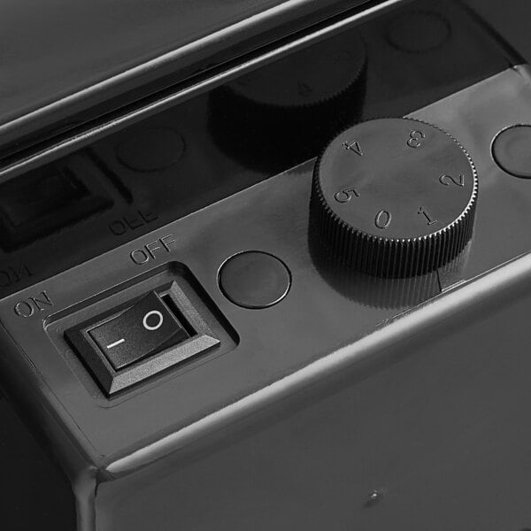 A close-up view of the control panel on a black countertop refrigerated merchandiser, showing an on/off switch and a numbered dial.