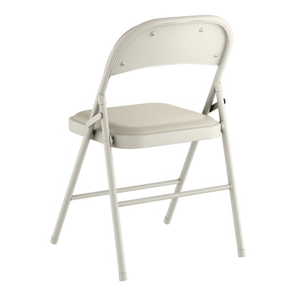 A beige vinyl folding chair with a padded seat and metal frame.