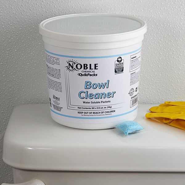 A white bucket of Noble Chemical QuikPacks toilet bowl cleaner with blue text and a blue object on it.