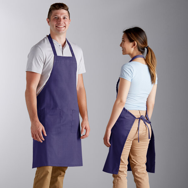 A man and woman wearing purple Choice bib aprons.