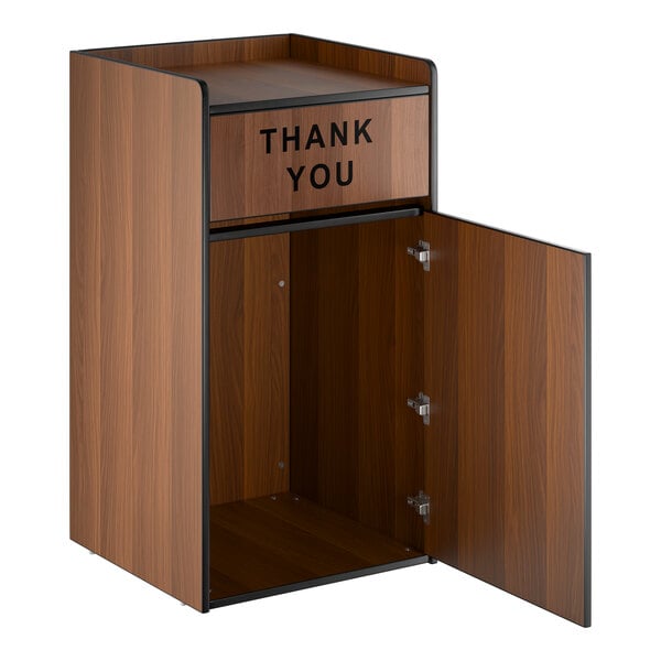 A walnut-colored waste receptacle enclosure with a swing door labeled 'THANK YOU' and an open lower cabinet.