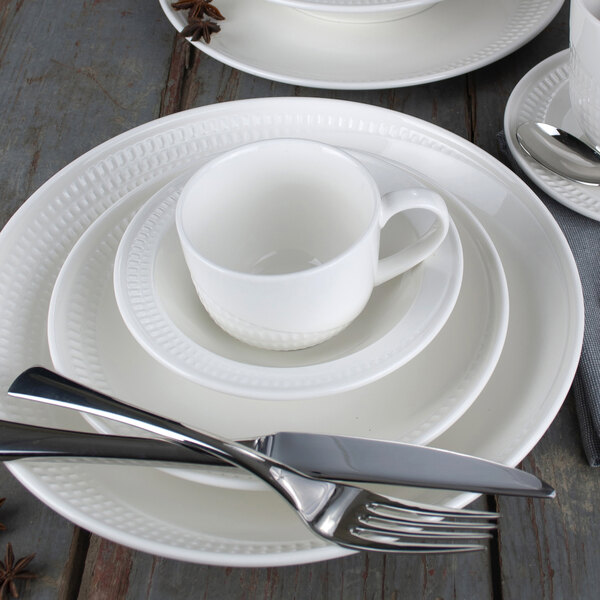 a white plate and silverware on a table