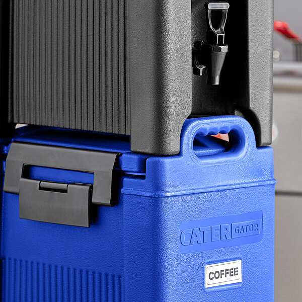 A blue CaterGator insulated beverage dispenser with a black lid on a counter.