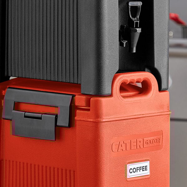 A red CaterGator insulated beverage dispenser on a counter.