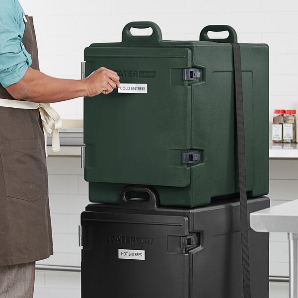 A person opening a large green CaterGator box.