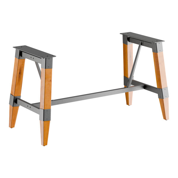 A standard height trestle table base with an industrial honey maple finish, designed for 30" x 72" table tops.