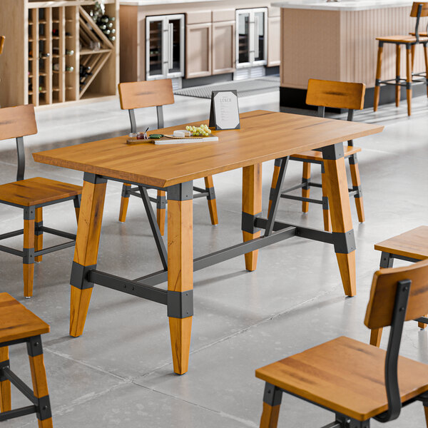 A standard height trestle table with a honey maple finish and industrial metal accents, designed for 30" x 60" table tops.