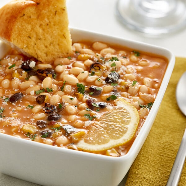 A bowl of dried navy beans with a slice of bread on top.