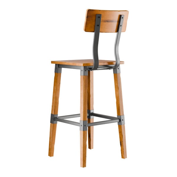 A Lancaster Table & Seating wooden bar stool with a metal frame and honey maple finish.