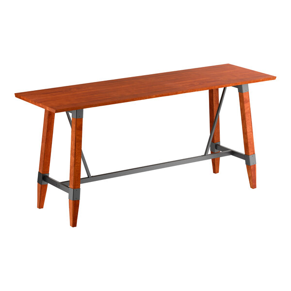 A rectangular bar-height table with a solid wood top in a reddish-brown finish and angled wooden legs connected by gray metal supports.